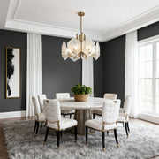 Dramatic dining room featuring a stunning gold geometric chandelier with faceted crystals over a round marble table.