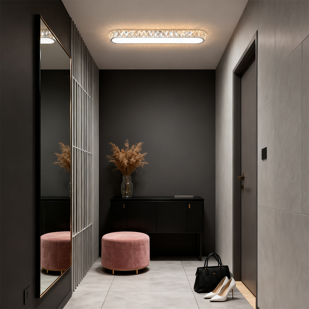 Dramatic LED flush mount light fixture with glass shade chandelier styling in luxurious dark-toned entryway with velvet seating.