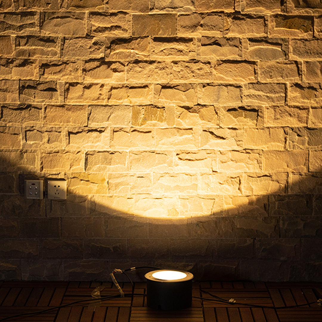 Dramatic uplighting showcasing natural stone wall construction with warm golden illumination