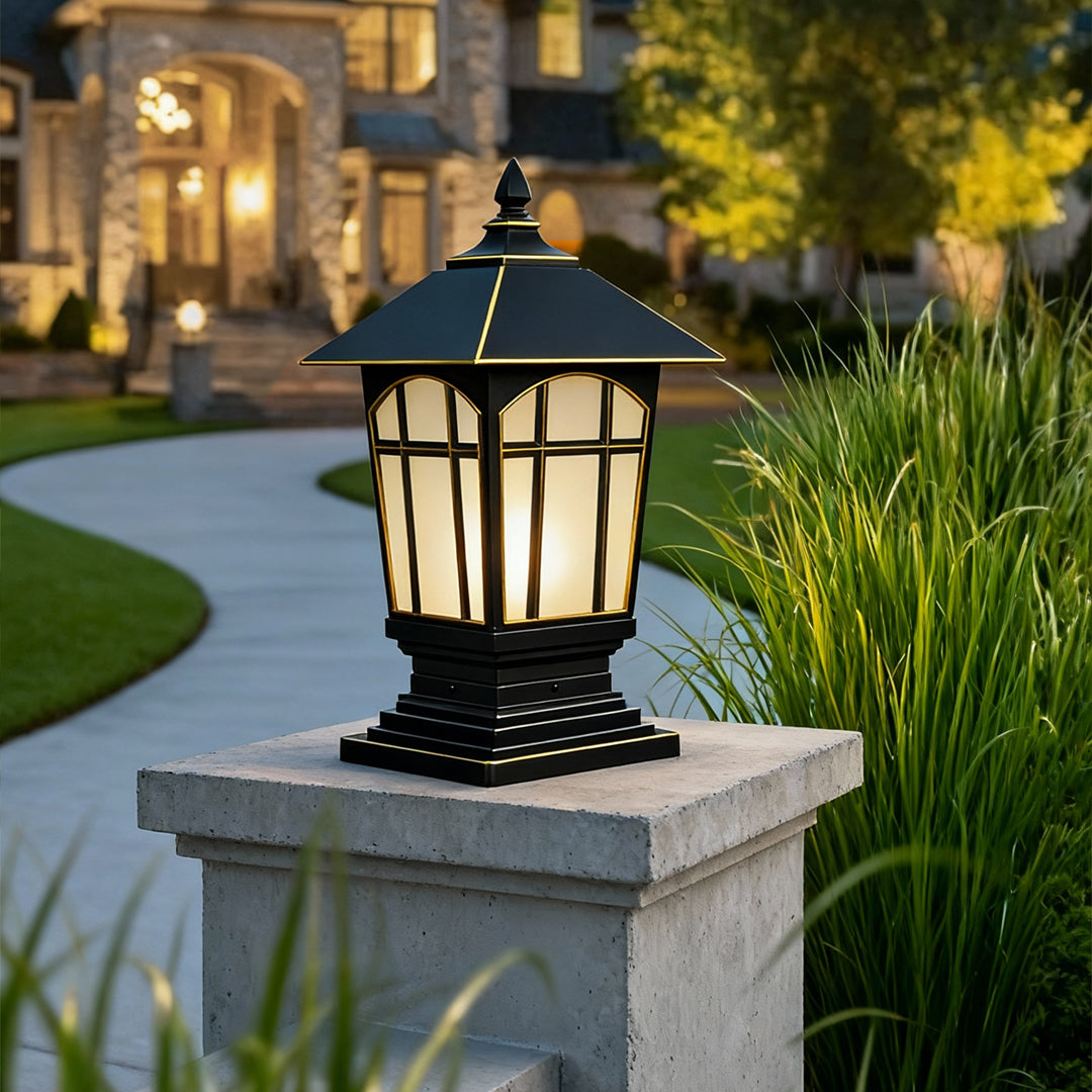 Large outdoor pillar lights placed on stone posts along a landscaped driveway.