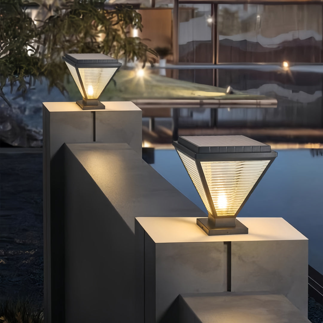 Minimalist pillar lights led decorating a driveway entrance at night.