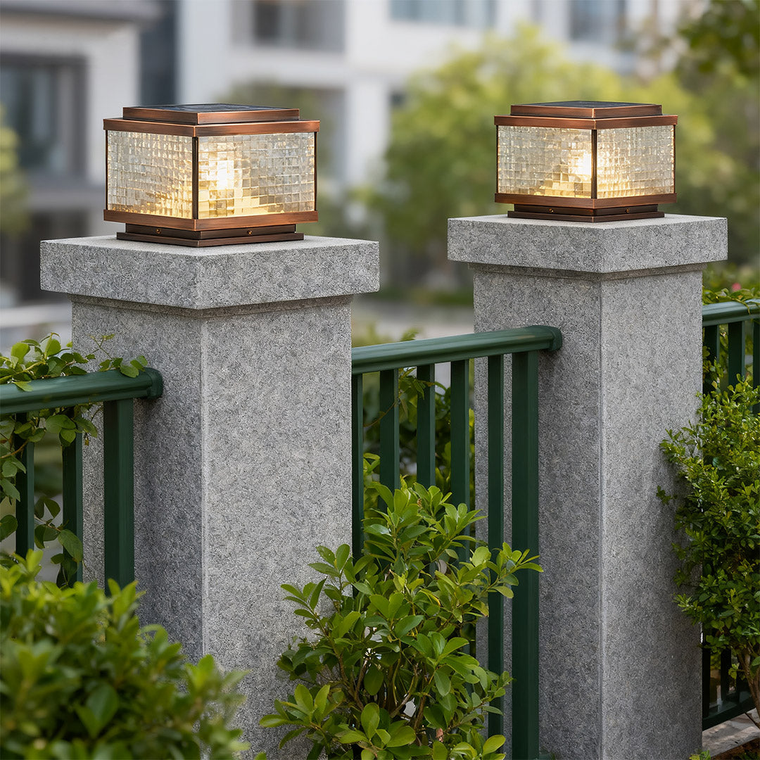 Pair of pillar cap lights on granite posts flanking modern driveway with residential landscaping