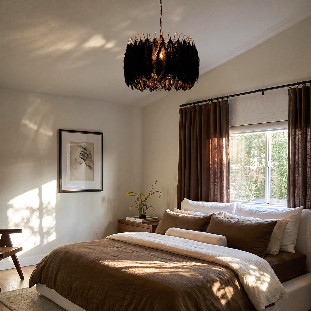 Black drum light chandelier hanging above a bed in a warm bedroom with brown curtains.