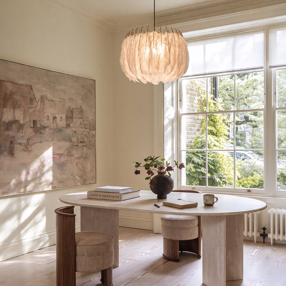 Drum light chandelier hanging above a round dining table in a bright room with large windows.
