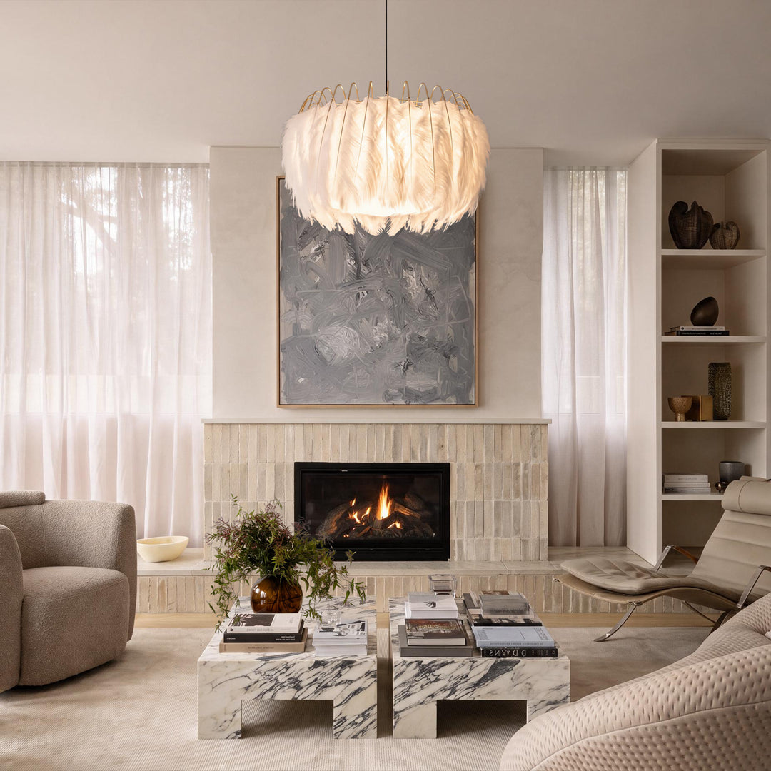 Drum light chandelier above a coffee table in a bright living room with a fireplace.