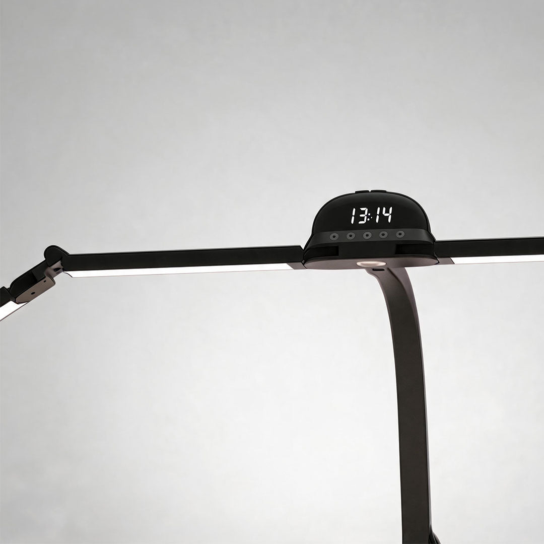 Close-up of a dual monitor light bar featuring adjustable arms, a digital clock, and a flexible center mount.