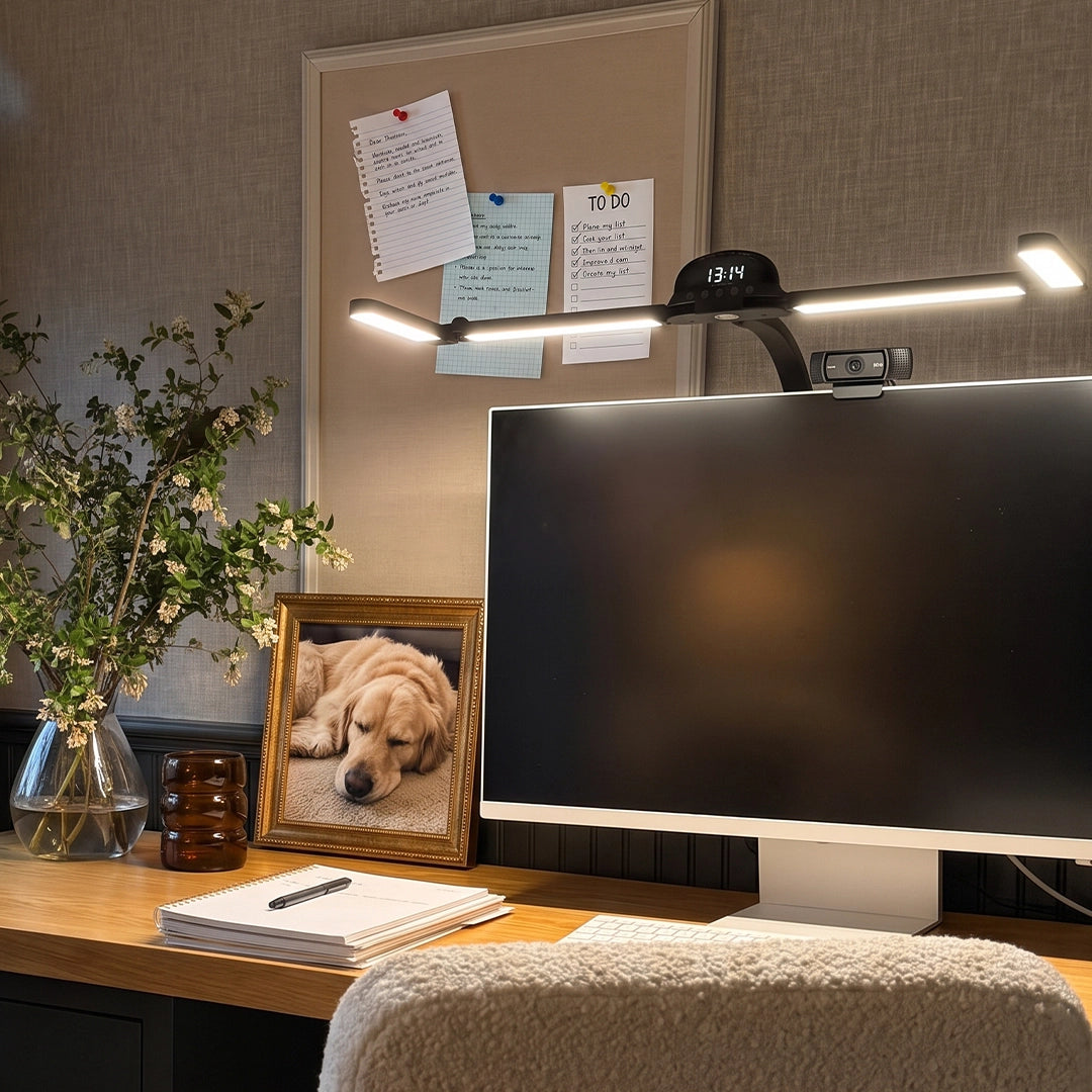 Dual monitor light bar mounted above a large computer screen in a cozy home office workspace.