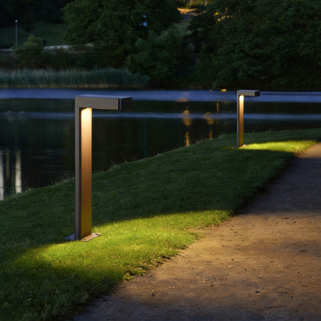 Durable L shaped landscape light illuminating a garden walkway at night.