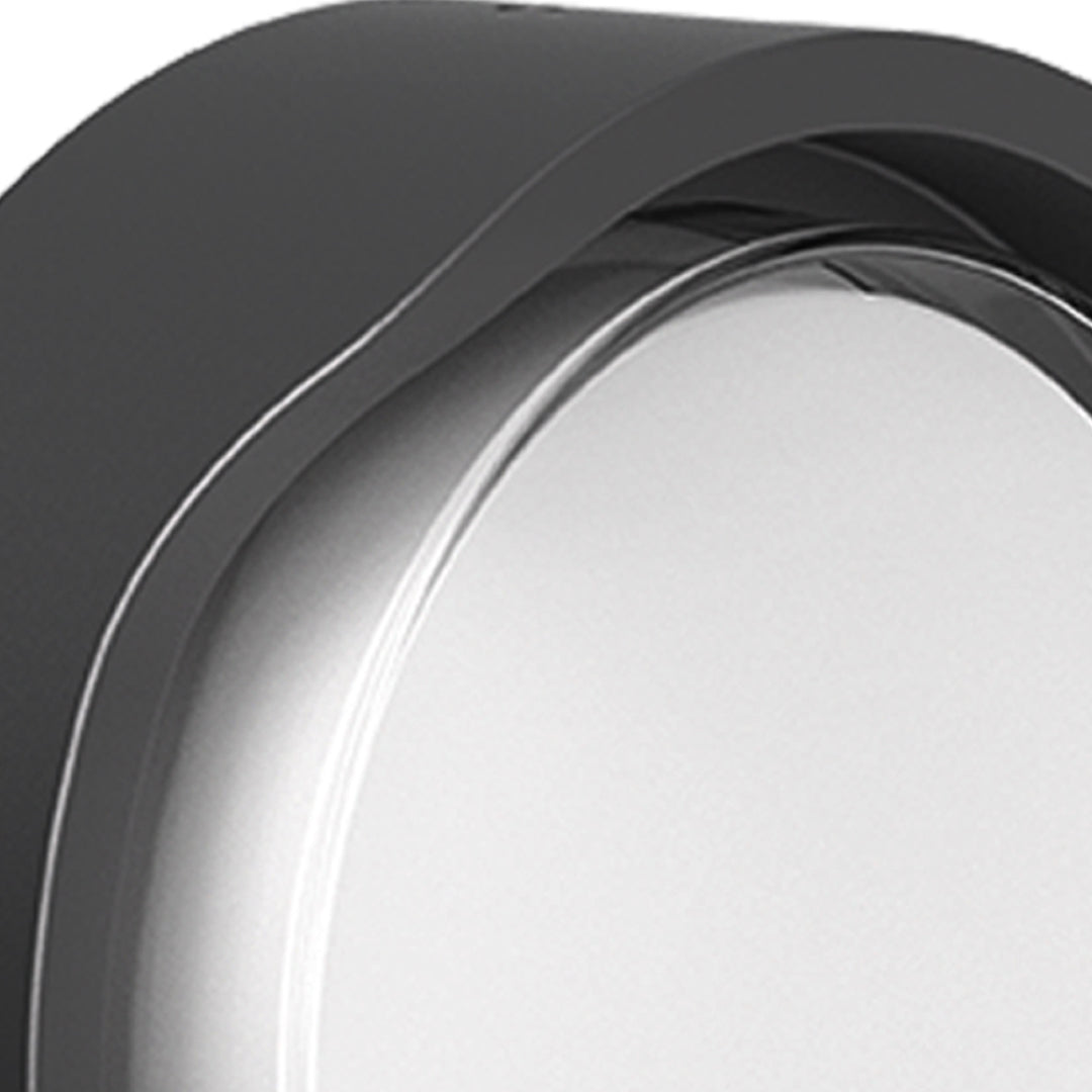 Round outdoor wall sconce with frosted diffuser creating ambient lighting on building exterior