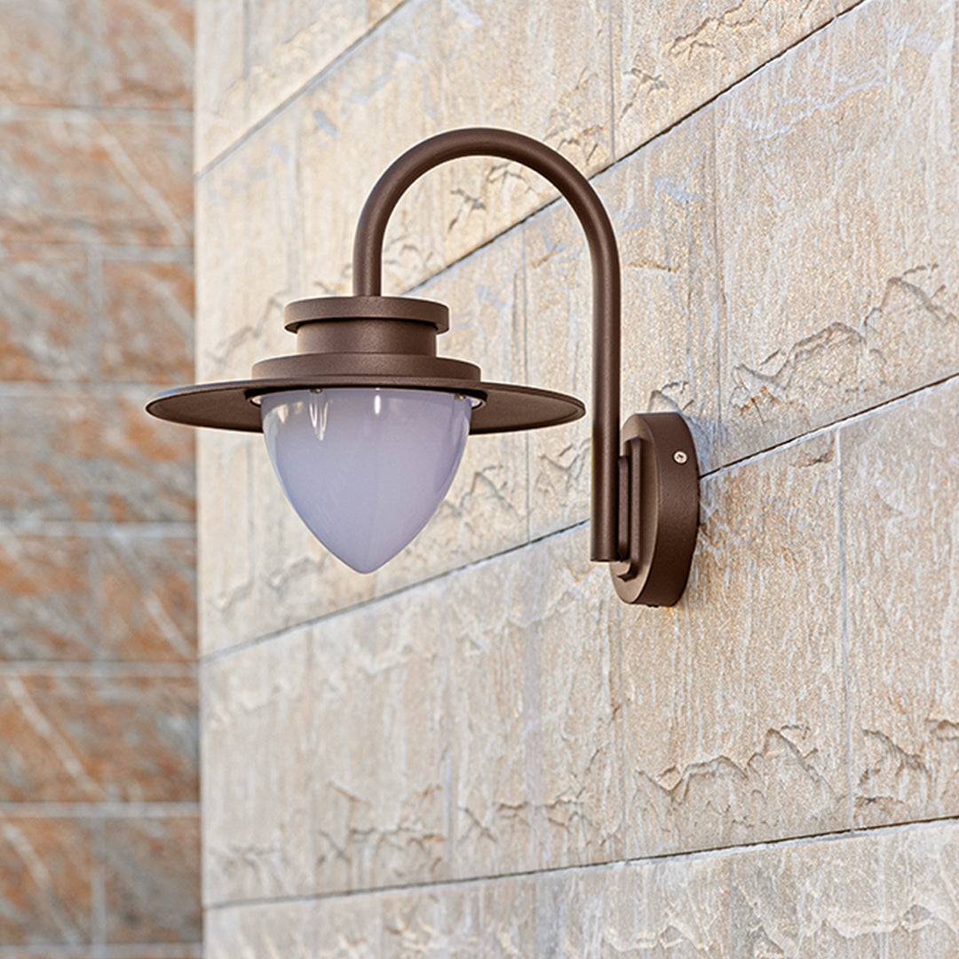 Contemporary wall sconce casting warm downward light on textured stone wall surface