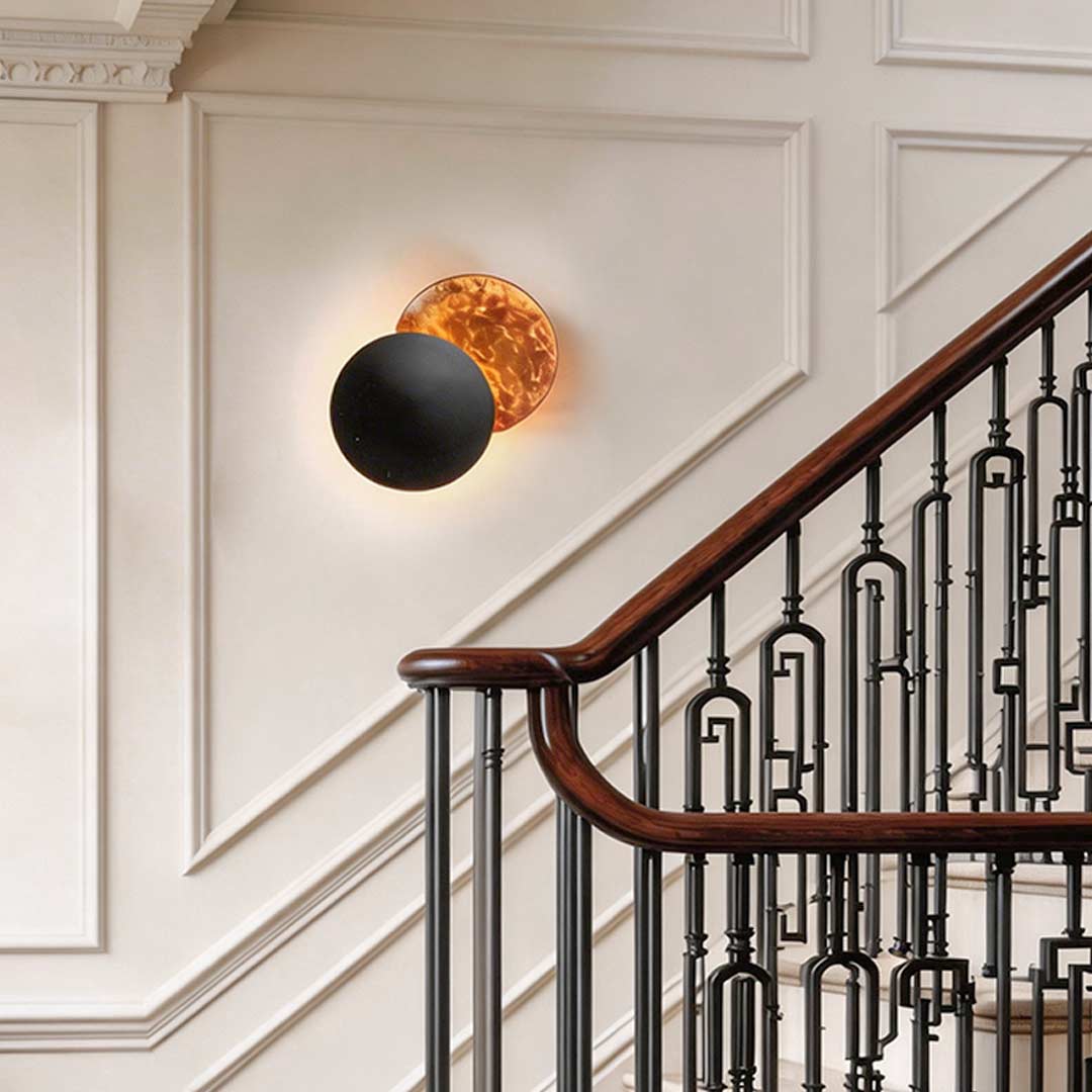 Eclipse wall lamp enhancing a stylish staircase with elegant directional light.