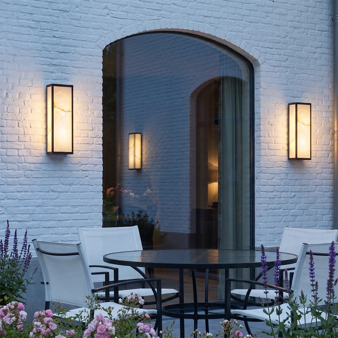 Pair of econic outdoor wall lights flanking an arched patio entry, adding warm illumination to a modern outdoor seating area.