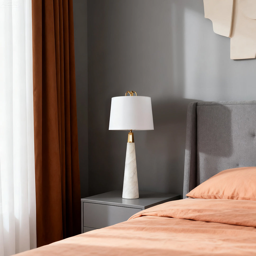 Modern white marble table lamp with beige lampshade in a cozy bedroom