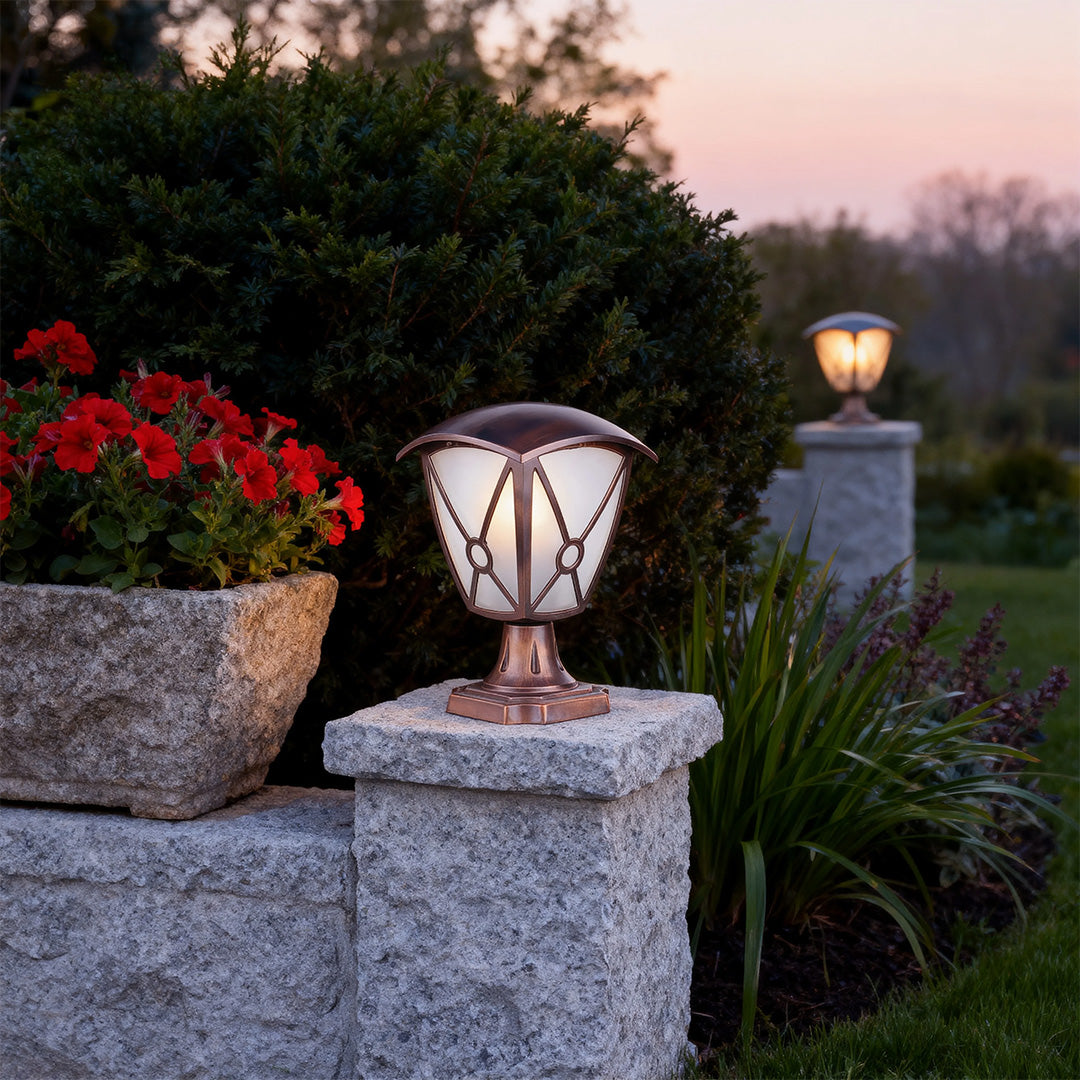 Elegant aluminum pillar light casting soft light on textured stone pier near flowering shrubs at twilight