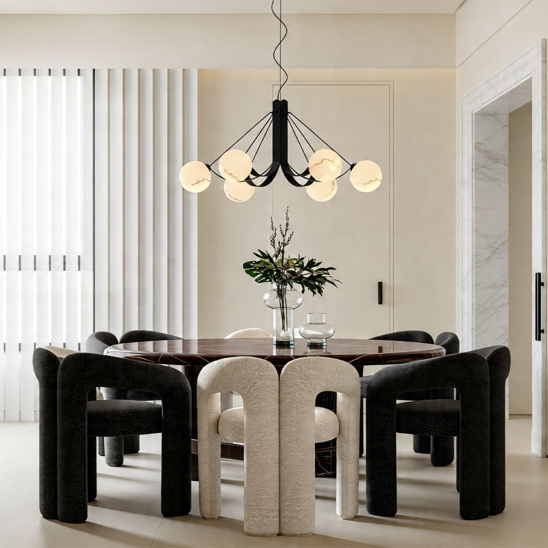 Elegant black chandelier with glass globes in a dining space featuring modern furniture and decor.