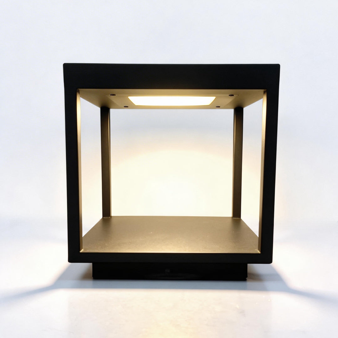 Elegant black concrete pillar light with warm LED light and hollow frame on white background.