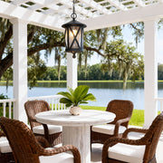 Elegant black outdoor pendant light hanging from white pergola over wicker furniture seating area