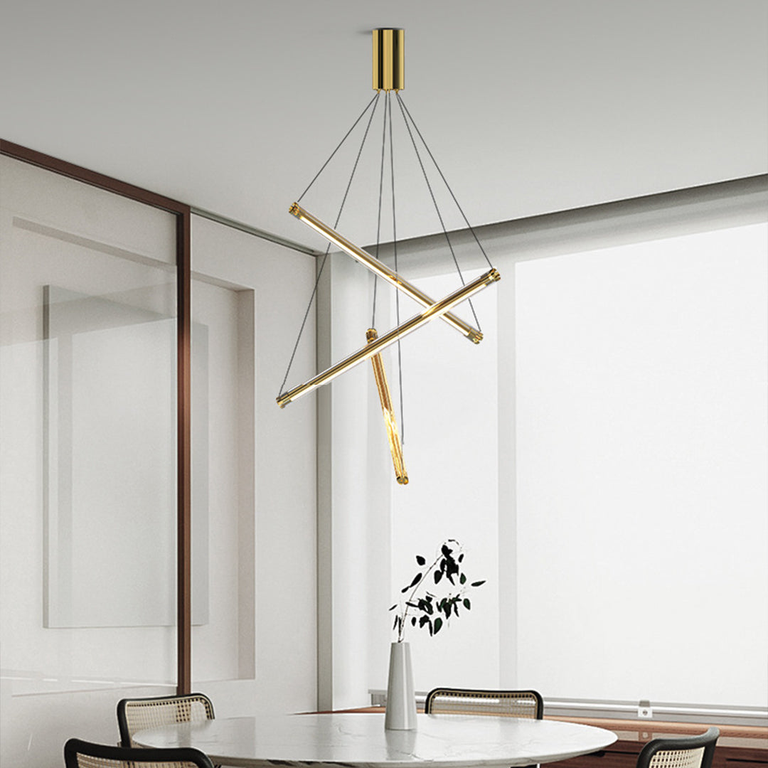 Elegant LED linear chandelier with brass crossed bars illuminating stylish dining area