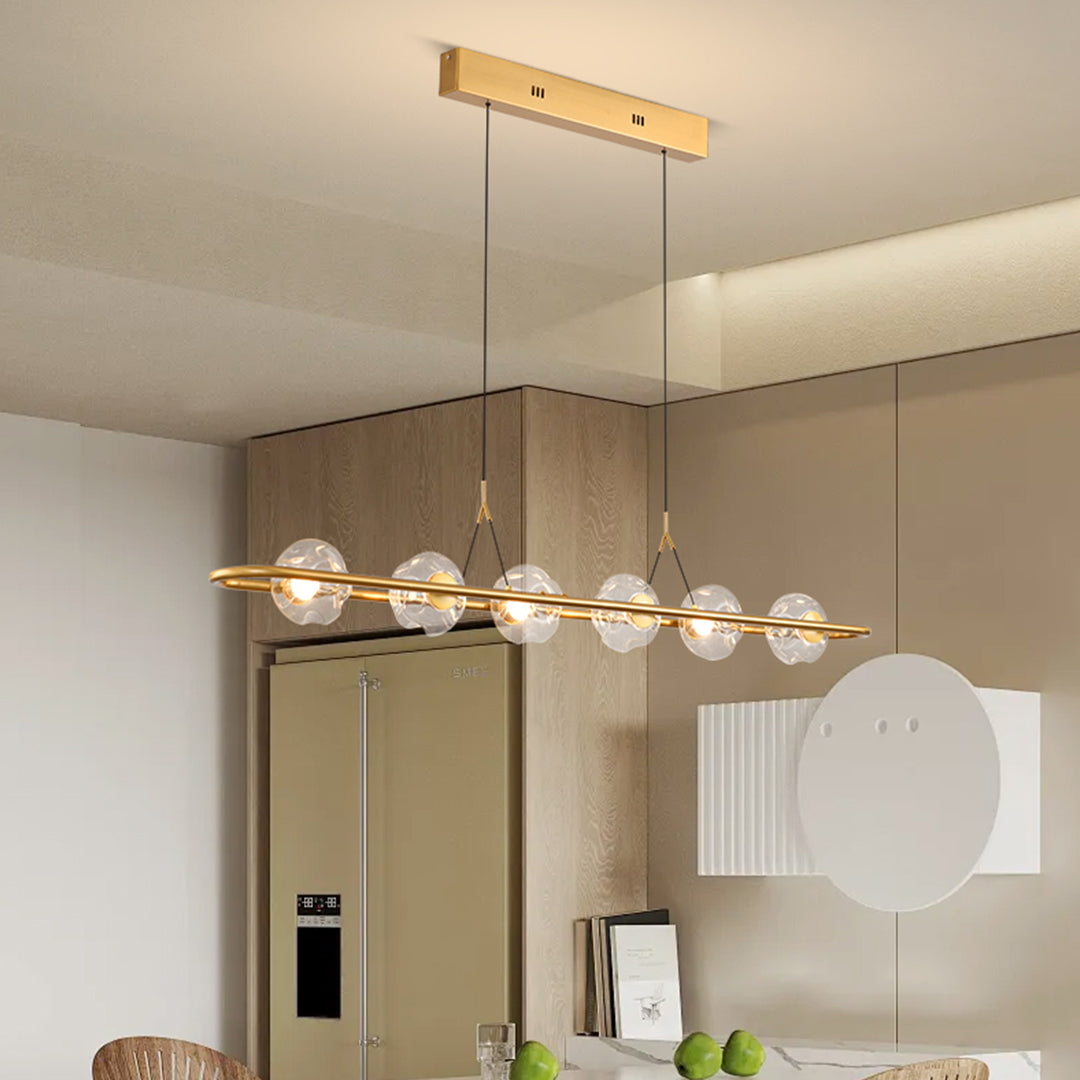 Elegant rise and fall pendant light with brass finish suspended over contemporary dining area