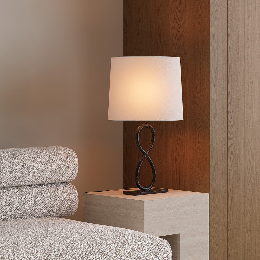 Elegant bronze metal lamp with fabric shade placed on nightstand for warm ambient lighting.