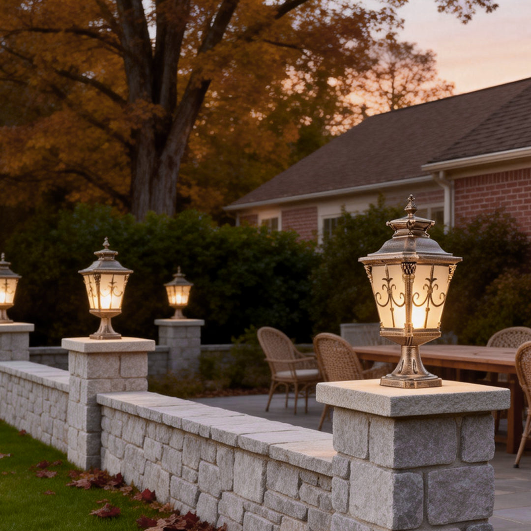 Elegant cast aluminum post light with intricate bronze detailing, illuminating a garden pathway at dusk.