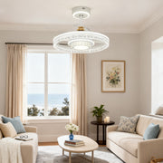 Elegant hidden blade ceiling fan with round light ring featuring sparkling crystal accents, installed in a bright, coastal living room. 