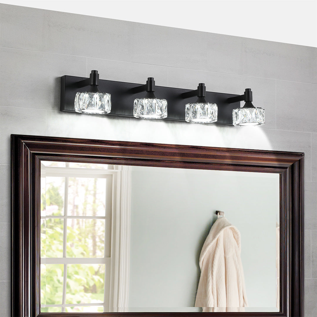 Elegant crystal bathroom vanity light with glass shade chandelier design illuminating dark wood-framed mirror in modern bathroom.