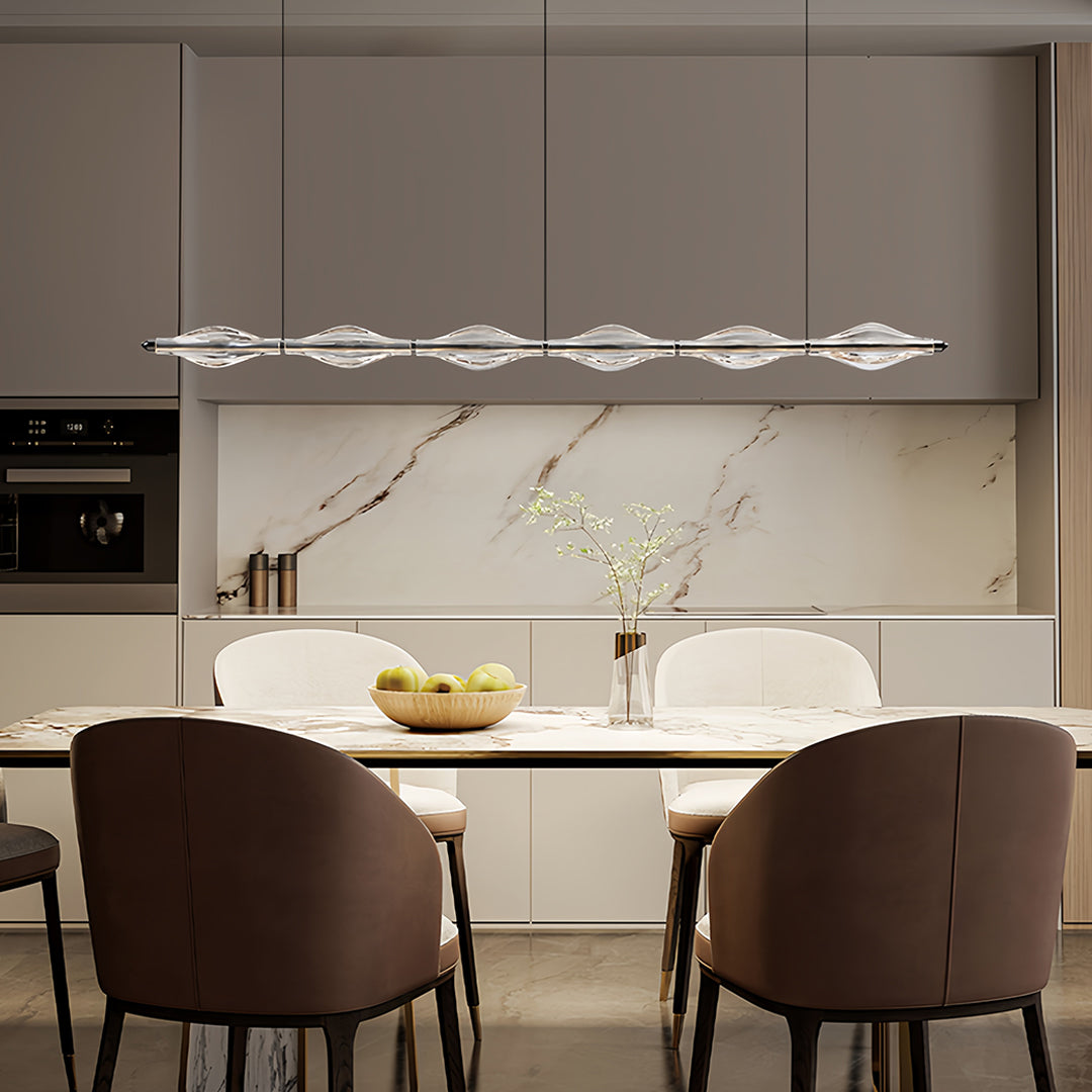 Elegant crystal pendant lights for kitchen island illuminating a contemporary kitchen with marble countertops.