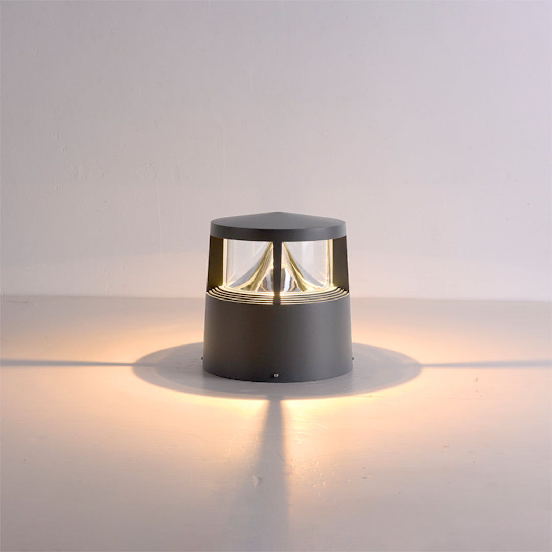 Elegant cylindrical bollard light positioned on surface showcasing warm LED glow pattern