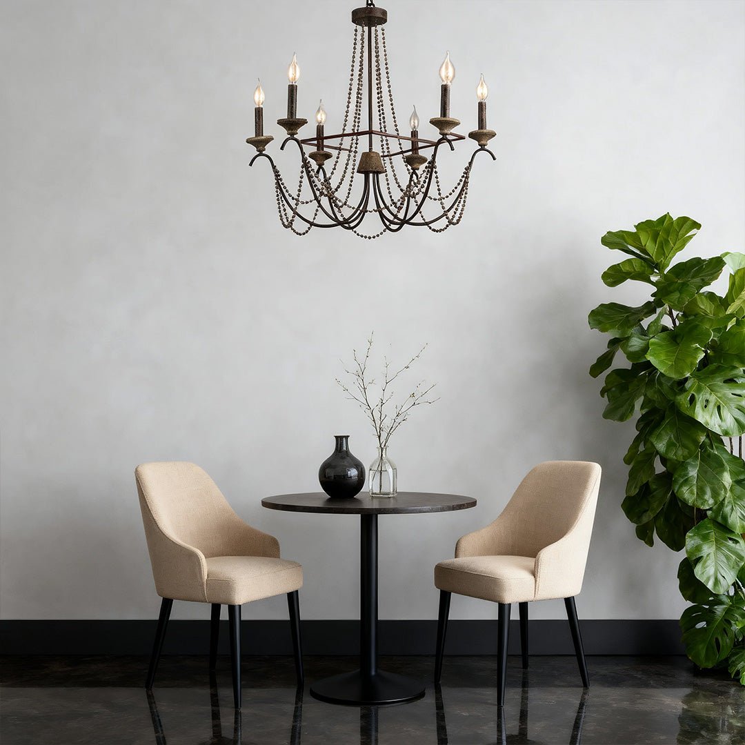 Elegant French style chandelier with dark bronze finish and intricate drape chains, providing classic ambiance above a small dining table.