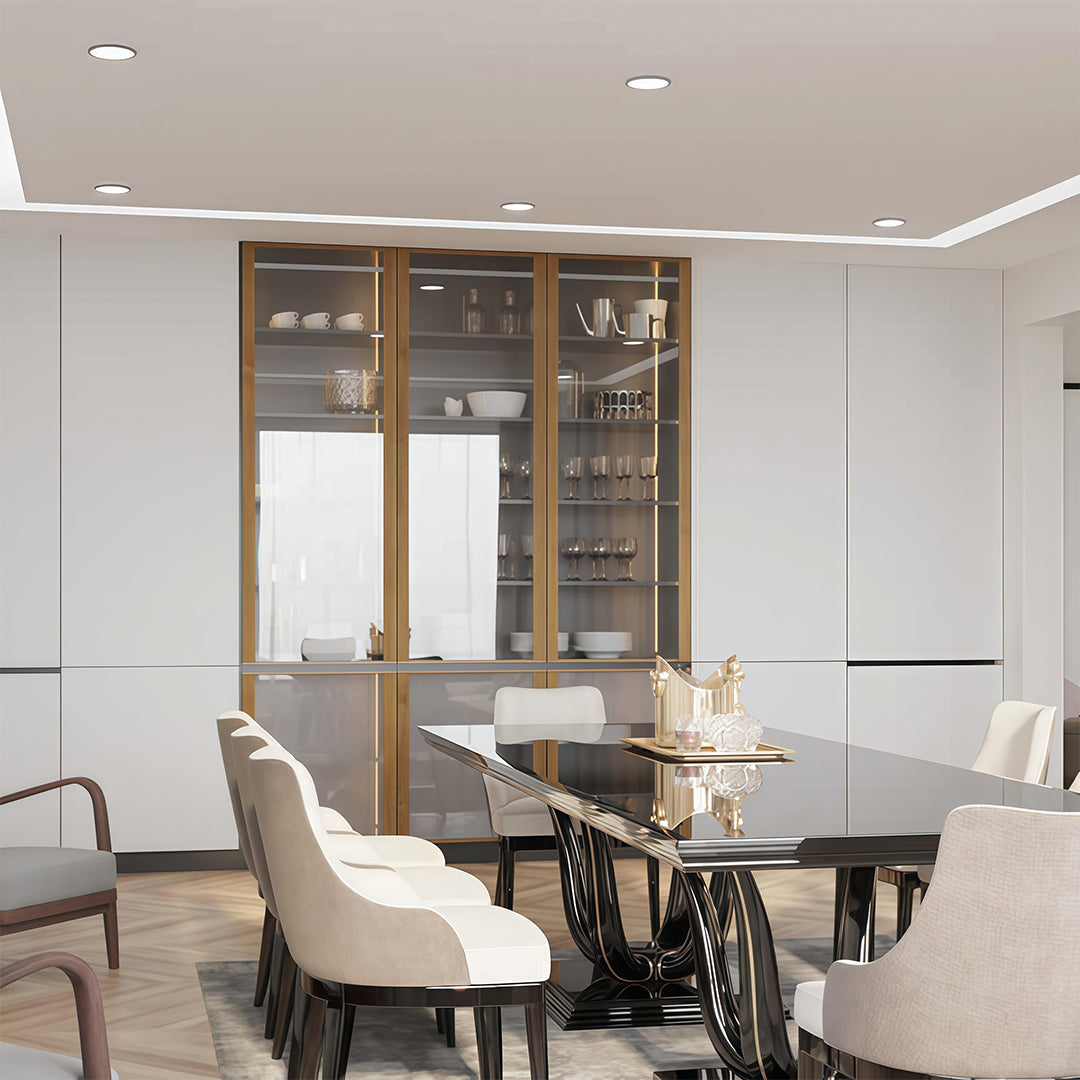 Elegant modern dining room with glass cabinets and a large table, illuminated by square recessed downlight fixtures.