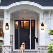 Elegant home entrance featuring traditional wall lanterns beside blue front door and stone accents