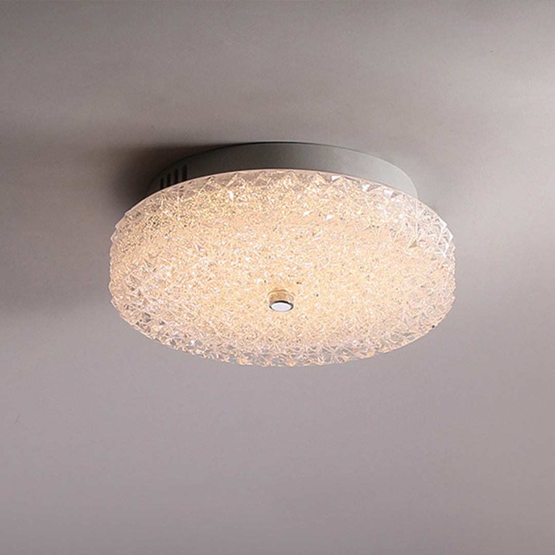 Elegant flush mount crystal ceiling light on a clean white ceiling casting a warm glowing aura.