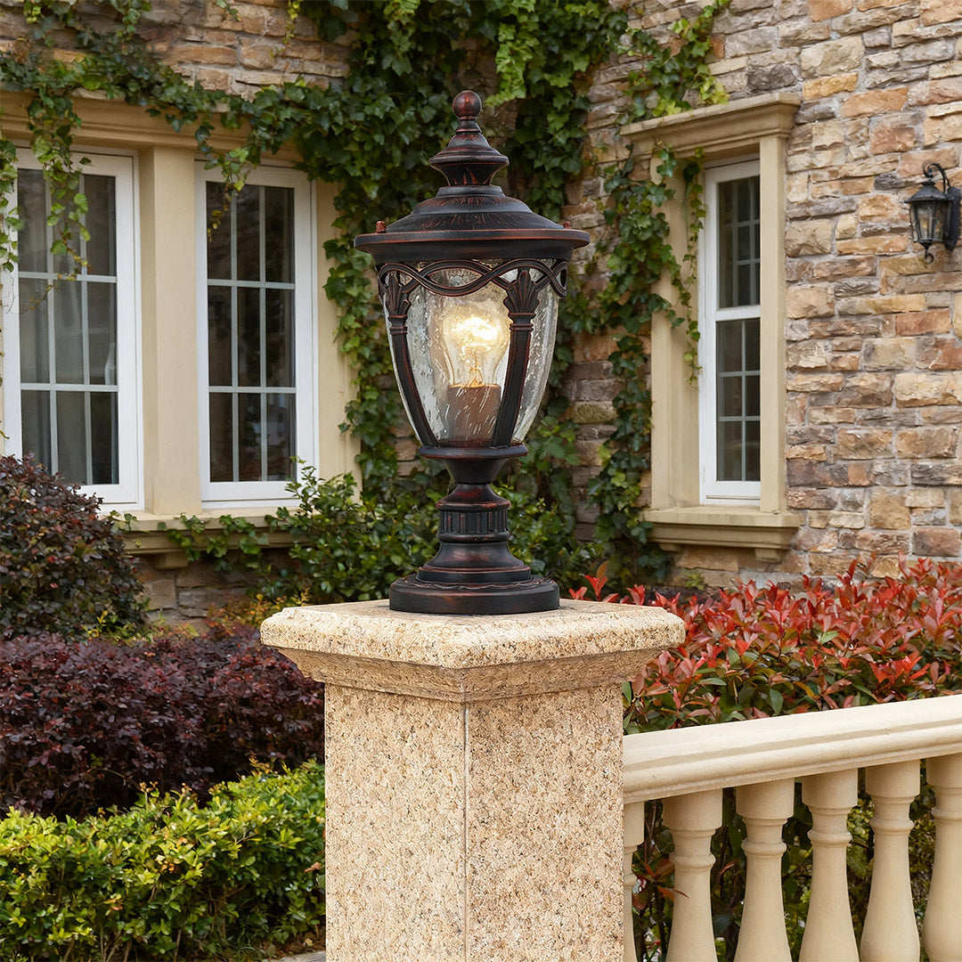 Elegant gate pillar light mounted on beige stone pier near brick facade with white balustrade