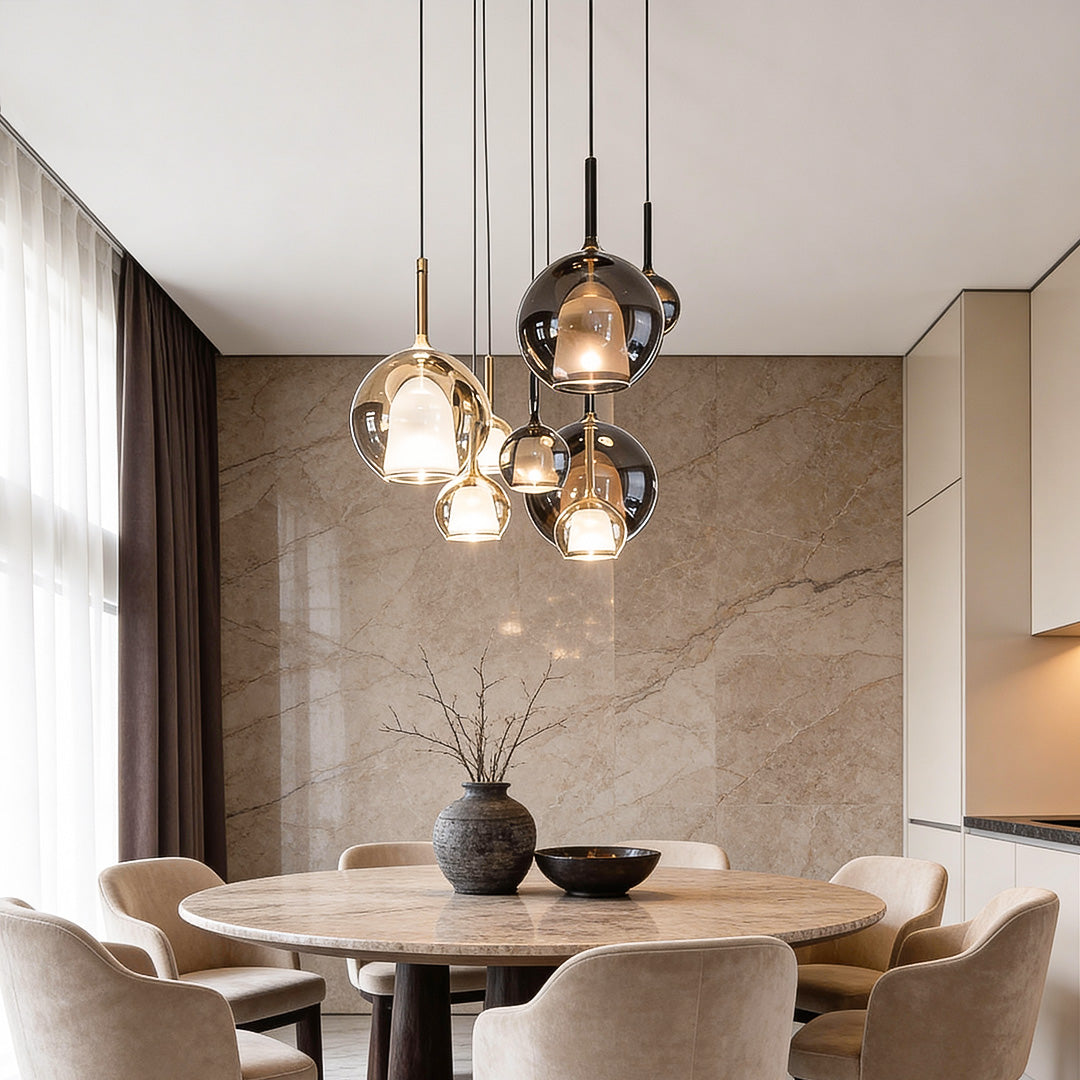 Elegant glass ball pendant light fixture illuminating a round dining table in a contemporary dining room.