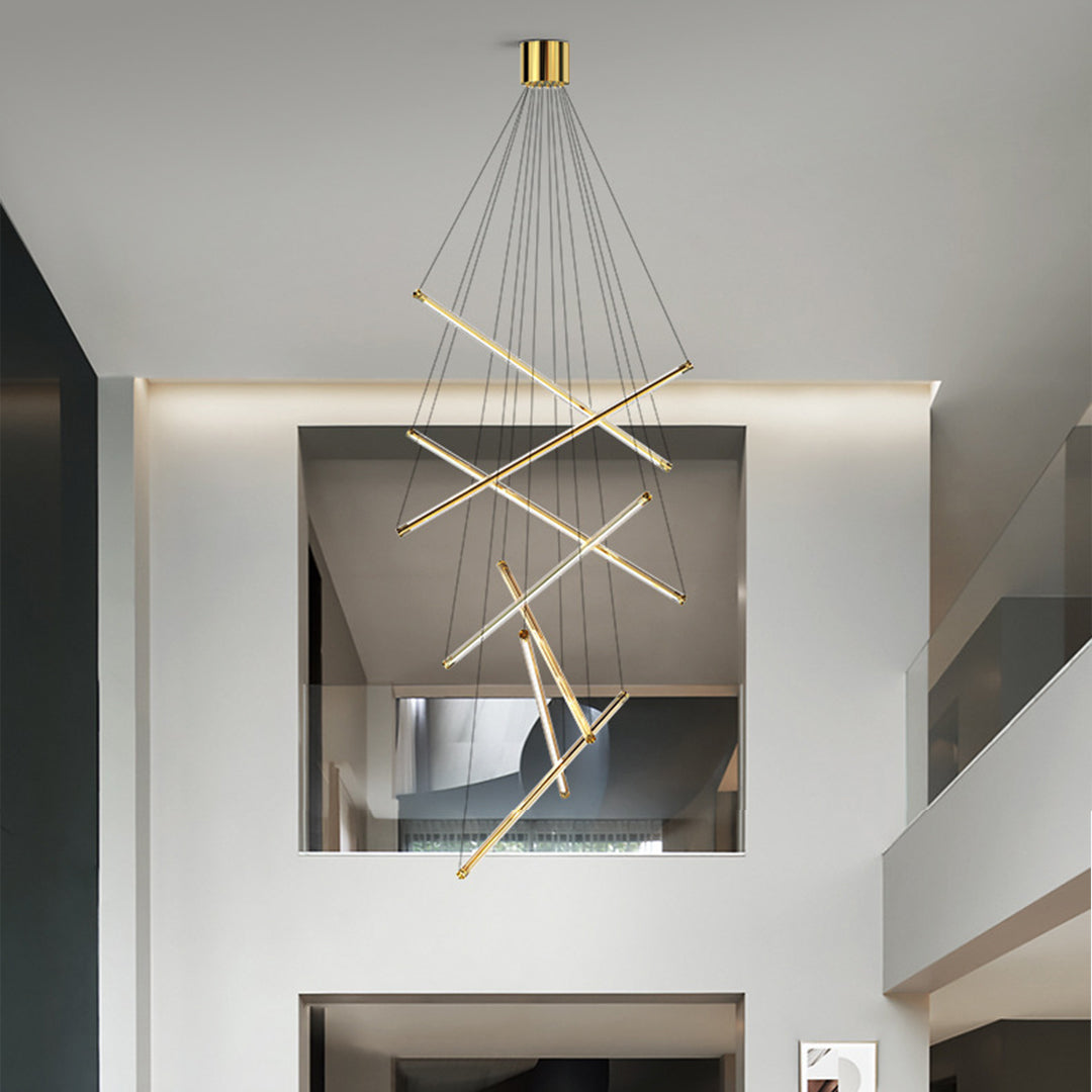 Elegant LED linear chandelier featuring gold bars and cables suspended above a white dining table in a contemporary space.