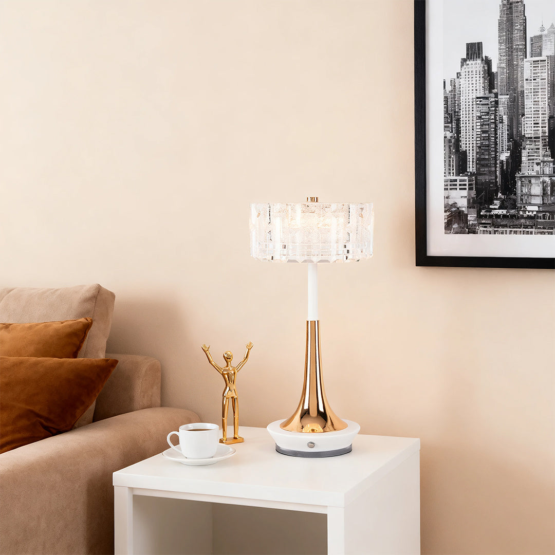 Elegant gold-finish cordless mushroom table lamp with a crystal shade on a white side table next to a sofa. 