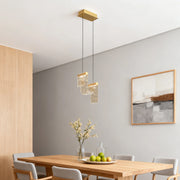 Elegant gold pendant island light hanging above wooden dining table in Scandinavian-style grey room
