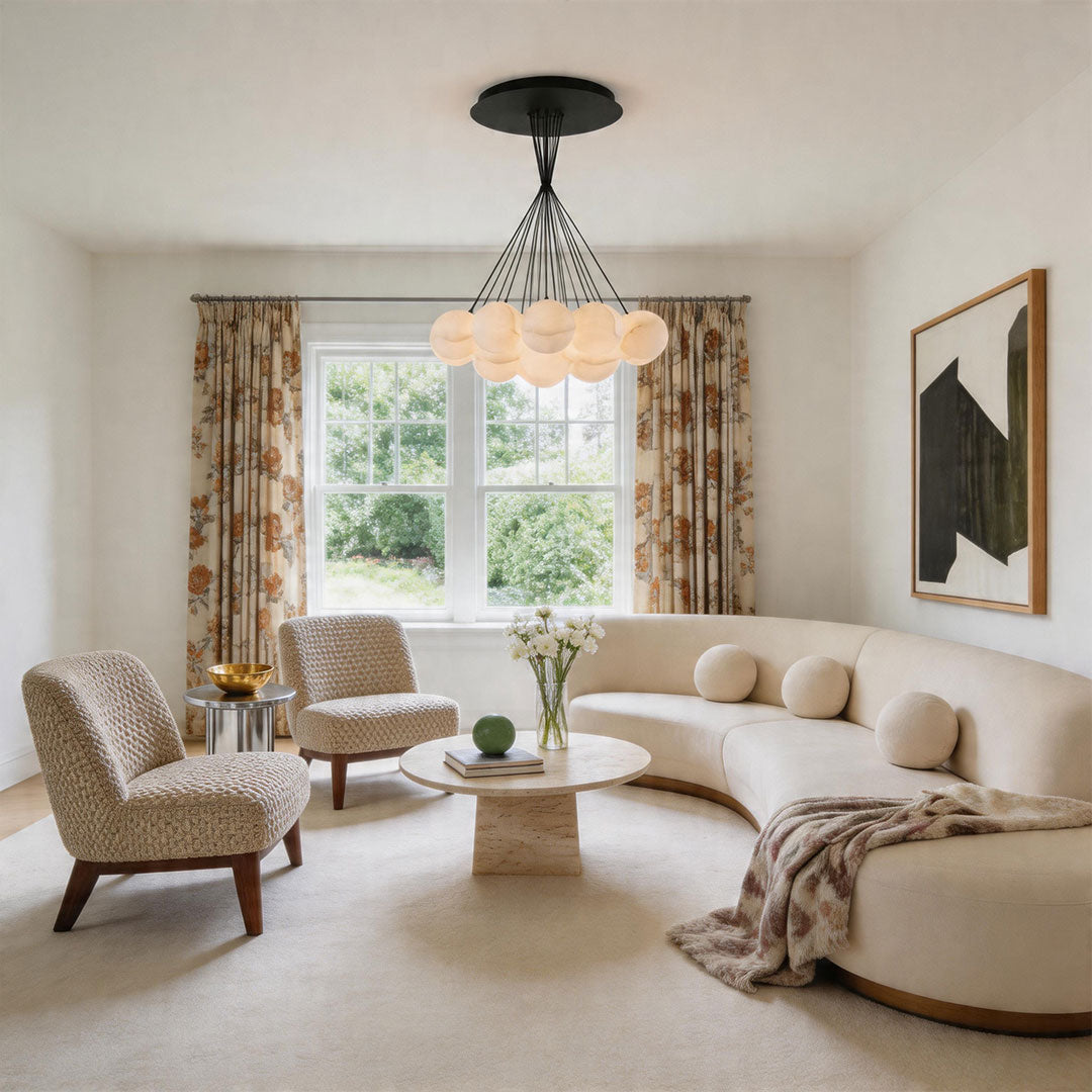 Elegant matte black chandelier with soft glowing globes in a modern living room setting.