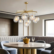 Elegant modern glass ball chandelier with multiple glass spheres, hanging above a dining table in a luxurious space.