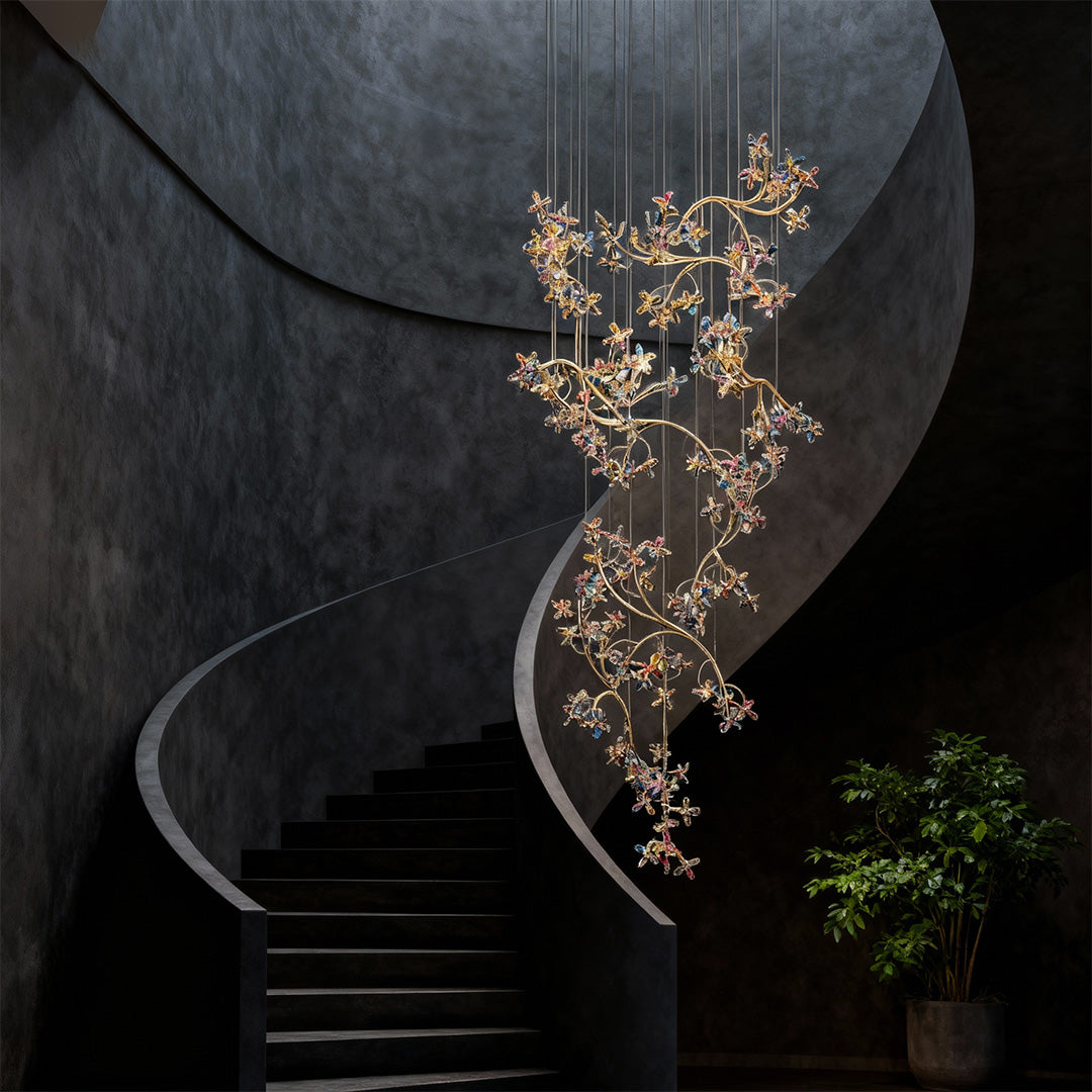 Elegant modern staircase chandelier featuring glass shade chandelier styling in sculptural cascading arrangement with delicate crystal leaves and flowers.