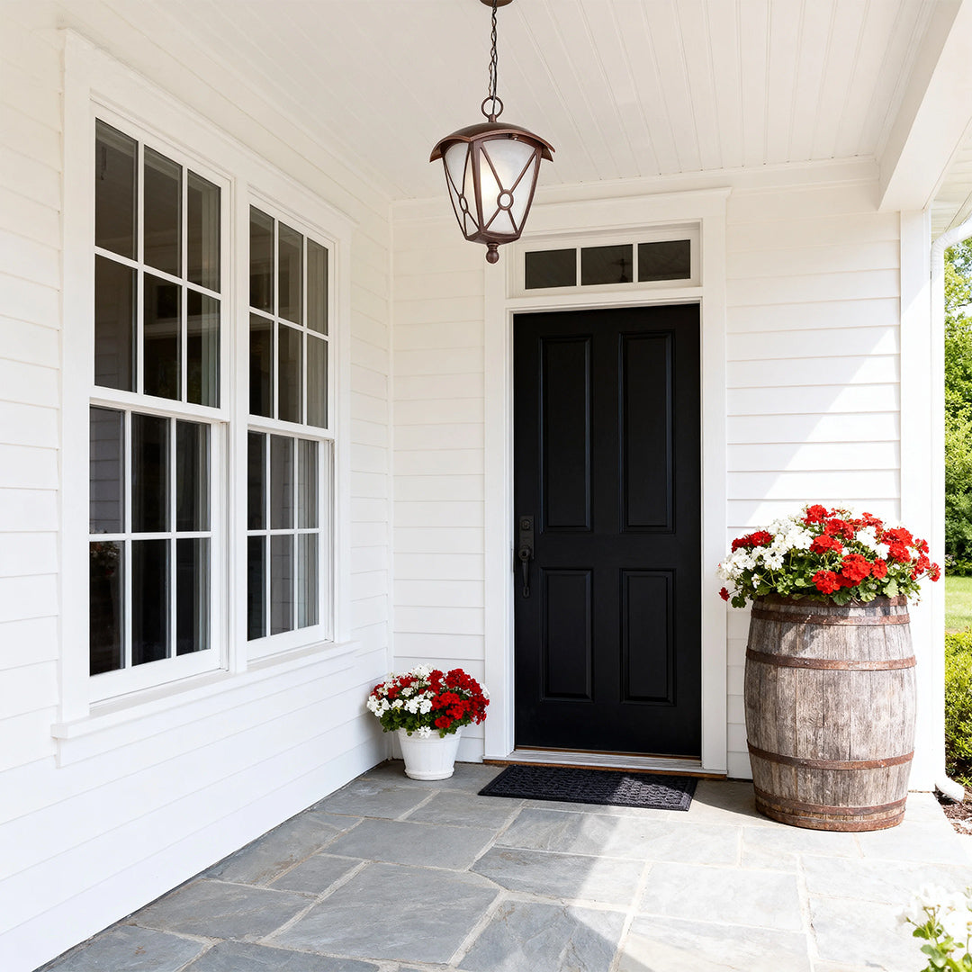 Elegant outdoor LED pendant light suspended from white porch ceiling near black front door entrance