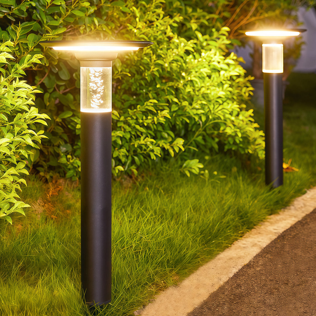 Elegant outdoor path lights solar fixtures with bubble glass, illuminating a grassy garden area.
