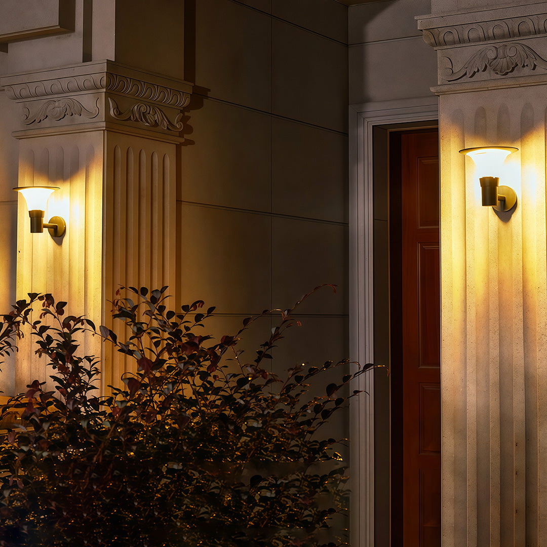 Elegant outdoor solar wall sconce fixtures illuminating the classical columns of a grand entryway at night.