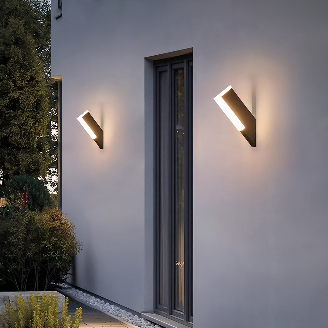Elegant outdoor wall lantern light fixtures casting warm light along minimalist exterior wall panels.