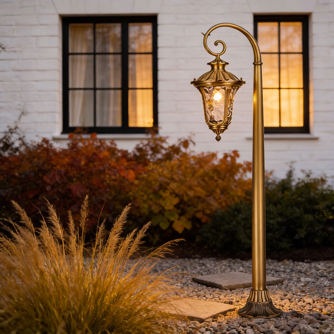 Elegant path lighting outdoor fixture illuminating a garden bed, highlighting lush plants and flowers at dusk.