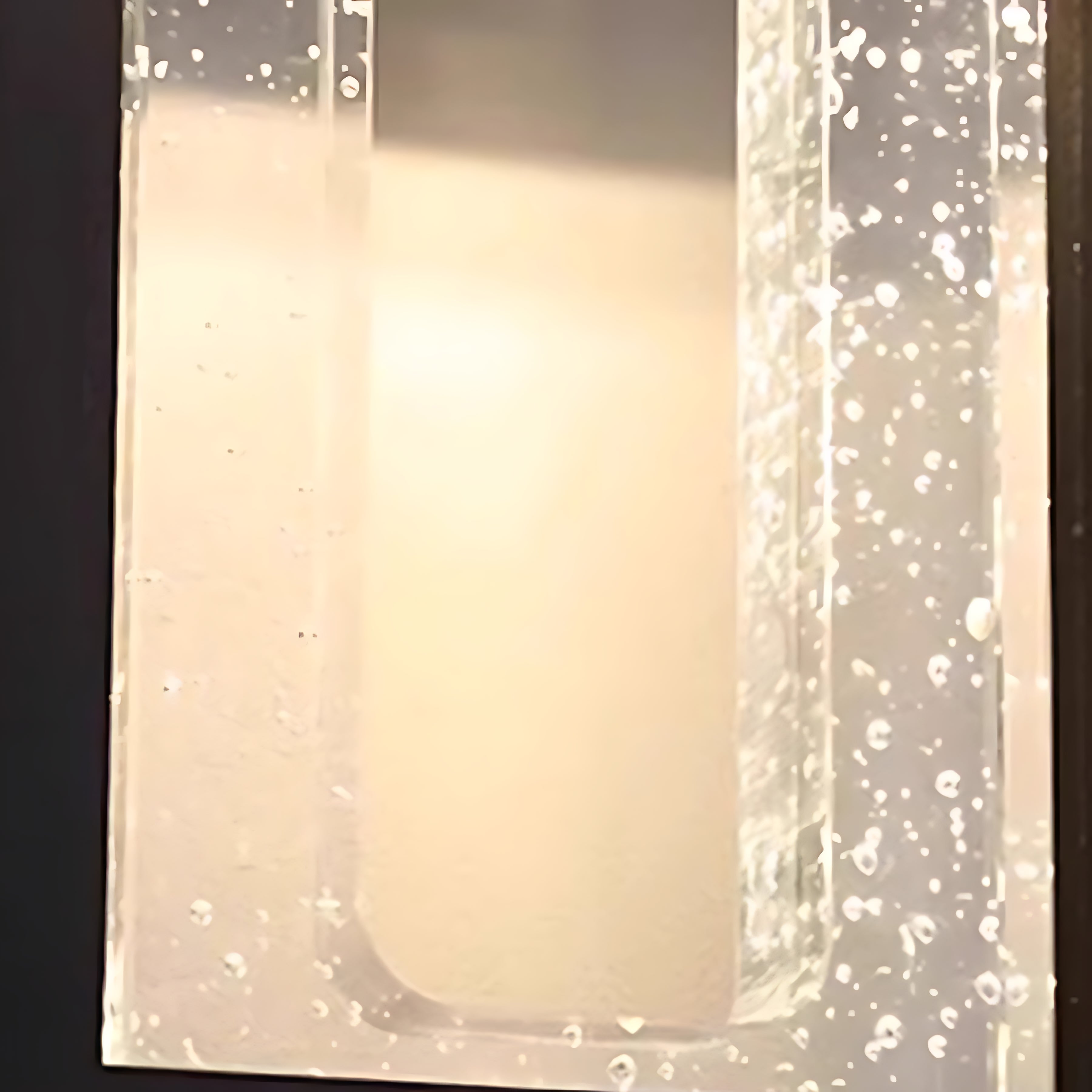 Elegant outdoor wall light with prismatic glass creating sparkled light pattern