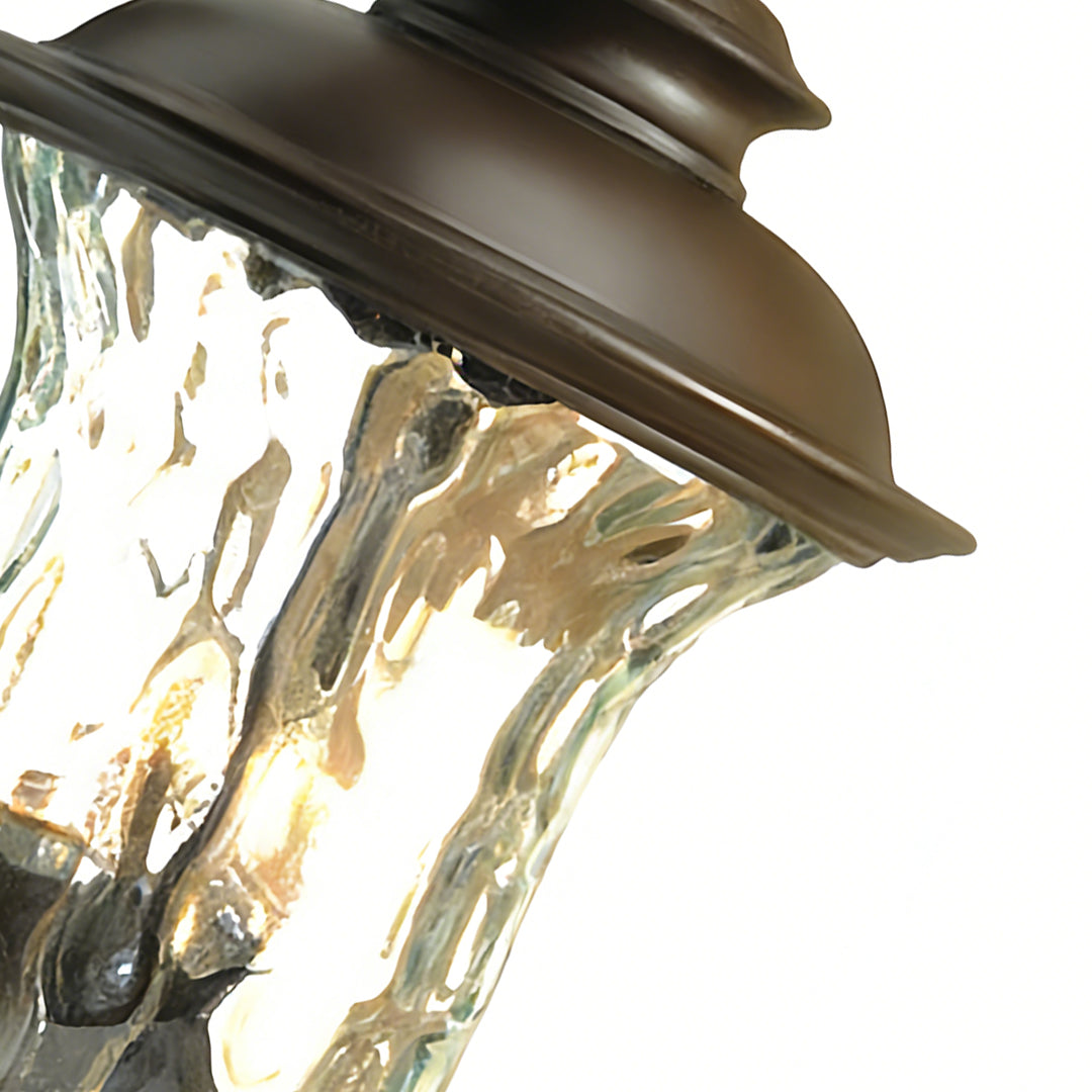 Elegant black exterior wall light featuring ribbed glass shade and warm illumination, ideal for stylish outdoor spaces.