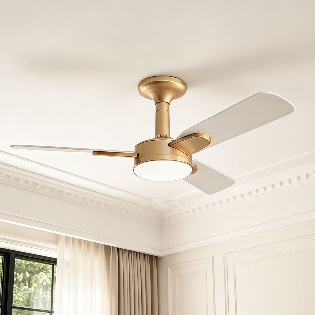 Copper ceiling fan with light installed beneath a decorative ceiling in a bright elegant room.