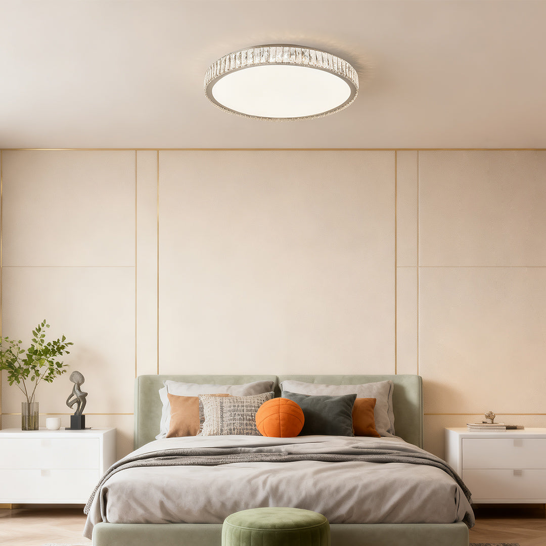 Elegant round modern crystal flush mount lighting fixture shining above a modern bedroom.
